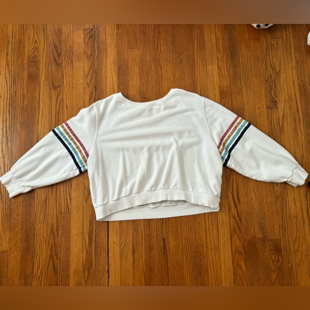 White crew neck with rainbow strips on a section of the arms